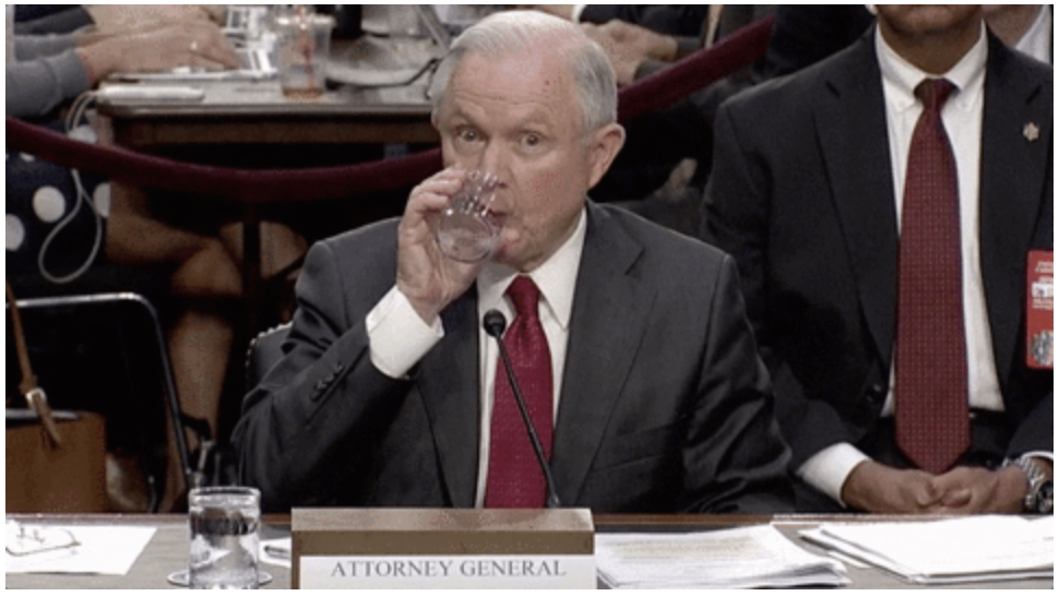 US Attorney General Jeff Sessions takes a sip of water.